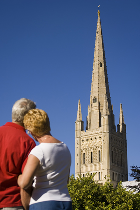 Couple looking towards the fine 15th Century spire of Norwich Cathedral